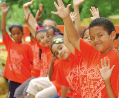 group of smiling children in orange shirts