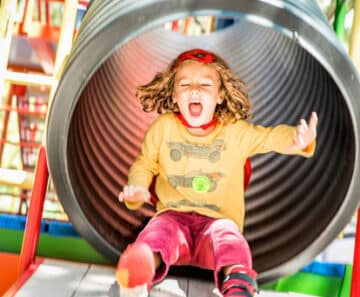 young girl coming out of tube slide